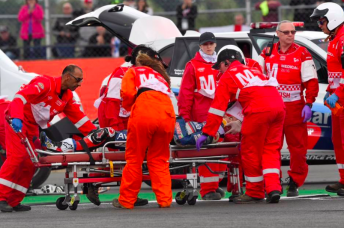 Loris Baz was stretchered away from an opening lap crash at the British Grand Prix